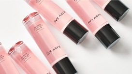 Six Mary Kay® Oil-Free Eye Makeup Remover bottles are scattered in a diagonal pattern.