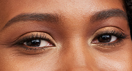 A close-up shot of a woman with brown eyes wearing mascara.
